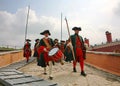 A detachment of historical reenactors in green and red uniform of the 18th century, markerwidth with weapons and drummer