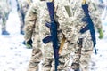 A detachment of soldiers with Kalashnikov assault rifles stand in formation to prepare for battle and offensive