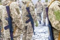 A detachment of soldiers with Kalashnikov assault rifles stand in formation to prepare for battle and offensive