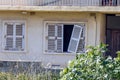 Detail of abandoned grunge yellow stone rural house with broken window and cactus growing in the garden Royalty Free Stock Photo