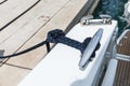 Detail of an anchor rope on a yacht, Stainless steel boat mooring cleat with knotted rope mounted on white yacht deck Royalty Free Stock Photo