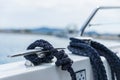 Detail of an anchor rope on a yacht, Stainless steel boat mooring cleat with knotted rope mounted on white yacht deck Royalty Free Stock Photo