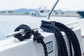 Detail of an anchor rope on a yacht, Stainless steel boat mooring cleat with knotted rope mounted on white yacht deck Royalty Free Stock Photo