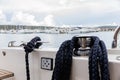 Detail of an anchor rope on a yacht, Stainless steel boat mooring cleat with knotted rope mounted on white yacht deck Royalty Free Stock Photo