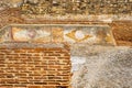 Detail of ancient geometric Roman paintings and frescoes and eroded earthy orange colors from the Mitreo Roman House of the