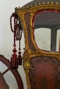 Detail of an ancient richly decorated wooden red and gold carriage
