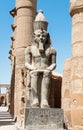 Detail of an ancient statue of an old pharaoh on a ruined temple in Egypt Royalty Free Stock Photo