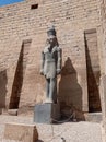 Detail of an ancient statue of an old pharaoh on a ruined temple in Egypt Royalty Free Stock Photo