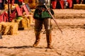 Detail the armor and shield of an actor disguised as a medieval knight in a spring festival for children