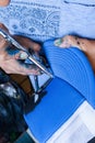 Detail of an Artist with airbrush coloring a blue hat