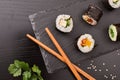 Detail of assorted sushi maki on slate and chopsticks top Royalty Free Stock Photo