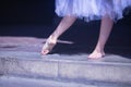 Detail of bare feet of ballerina exercising on the floor under a white tutu Royalty Free Stock Photo