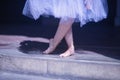 Detail of bare feet of ballerina exercising on the floor under a white tutu Royalty Free Stock Photo