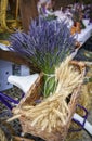 Detail of a basket on a bicycle carrier with a bouquet of lavender flowers and a bunch of ears of wheat at a street market Royalty Free Stock Photo