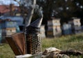 detail of beekeeper smoker to calm bees in beehive metal smoke early morning frame with honeycomb sun Royalty Free Stock Photo