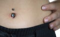 Detail of the belly of a young woman, wearing a navel piercing Royalty Free Stock Photo