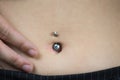 Detail of the belly of a young woman, wearing a navel piercing Royalty Free Stock Photo
