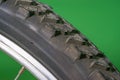 detail of a black bicycle tire with fur on the surface.  green background. Royalty Free Stock Photo