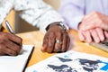 Detail of black business man signing documents.