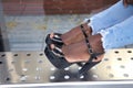 Detail of black high heeled shoes of African American woman leaning on the seat of a bus stop. Fashion concept, shoes, feet, heels Royalty Free Stock Photo