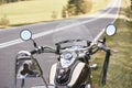 Detail of black shiny high-speed motorcycle parked on roadside on blurred sunny outdoors background. Royalty Free Stock Photo