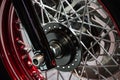 Detail of the black wheel of a customized motorcycle chromed with red and silver wheels