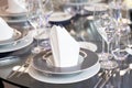 Detail of black and white modern banquet setting on glass table. Blurry background