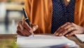 Detail of black woman hands writing on paperwork