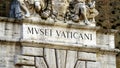 Detail of black writing on white marble Vatican Museums written in Italian at the external entrance of the museums on the Vatican