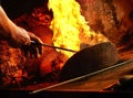 Detail of blacksmith s forge with strong flames. Mans Hands setting up fire in forge Royalty Free Stock Photo
