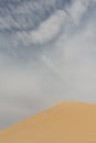 Detail of blowing sand in the wind of the top of a sanddune, rescaping the landscape and forming new sanddunes Royalty Free Stock Photo