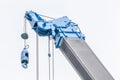 Detail of blue construction crane for heavy lift using in construction industry with white background. Royalty Free Stock Photo