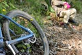 Detail of blue mountain bike in forest with resting kid Royalty Free Stock Photo