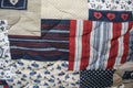 Detail of blue and red patchwork quilt with hand quilting