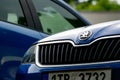 Detail of blue Skoda Rapid, its badge, grill and hood
