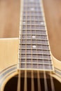 Detail of the body of a light wood guitar, soundhole, fretboards and strings Royalty Free Stock Photo