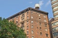 Detail of a brick apartment building with water  tower on the roof Royalty Free Stock Photo