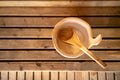 Detail of bucket and wood spoon on a wooden bench. Small interior sauna