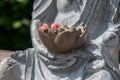 Detail of a Buddha statue with flowers in hands Royalty Free Stock Photo