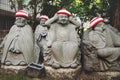 Detail of Buddha statues with knitted hat offerings at the temple Diasho-in in Miyajima, Hiroshima, Japan Royalty Free Stock Photo