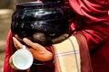 Detail of buddhist monk hands holding a bowl and cup Royalty Free Stock Photo