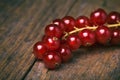 Detail bunch of red currants on a old wooden table.