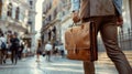 Detail of a businessman holding a leather briefcase downtown. Wide image with large copy space