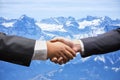 Businessmen shaking hands on Snow mountain in Switzerland background