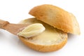 Detail of butter spread on a cut crusty bread roll with a wooden Royalty Free Stock Photo