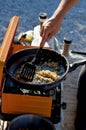 Detail of camper frying onions in a pan on an orange stove Royalty Free Stock Photo