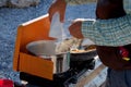 Detail of camper pouring a package of instant mashed potatoes into a pot of boiling water on a camp stove Royalty Free Stock Photo