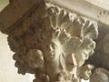 Capital with engraved sculptures of faces in the Abbey of Fossanova in Italy.