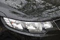 Detail of car headlights lamp, black modern car front lamp and raindrops Royalty Free Stock Photo