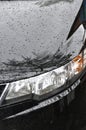 Detail of car headlights lamp, black modern car front lamp and raindrops Royalty Free Stock Photo